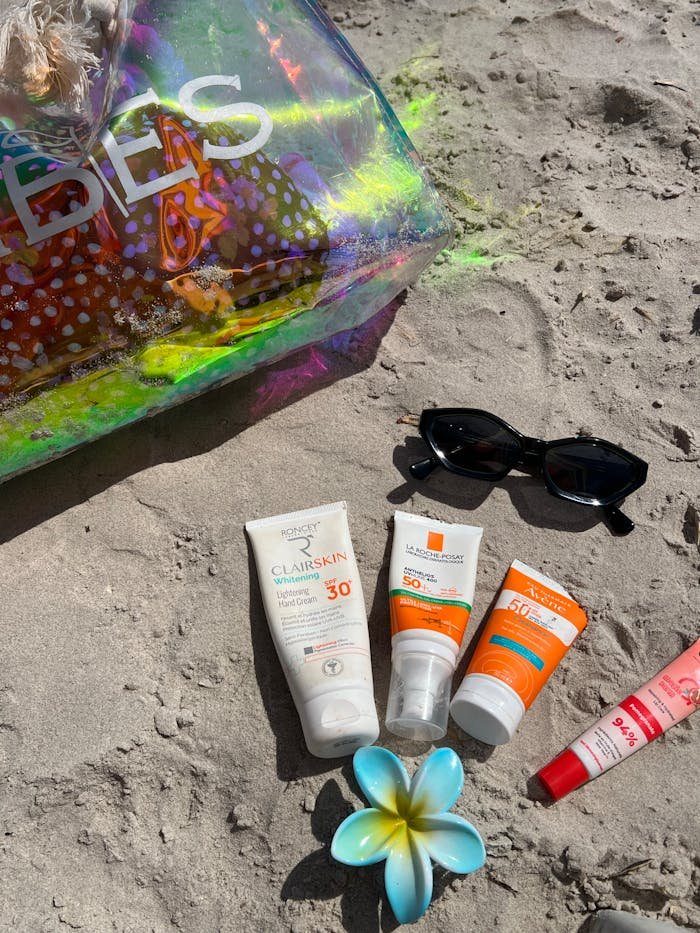 beach-essentials-with-sunscreen-on-sandy-shore-33587973